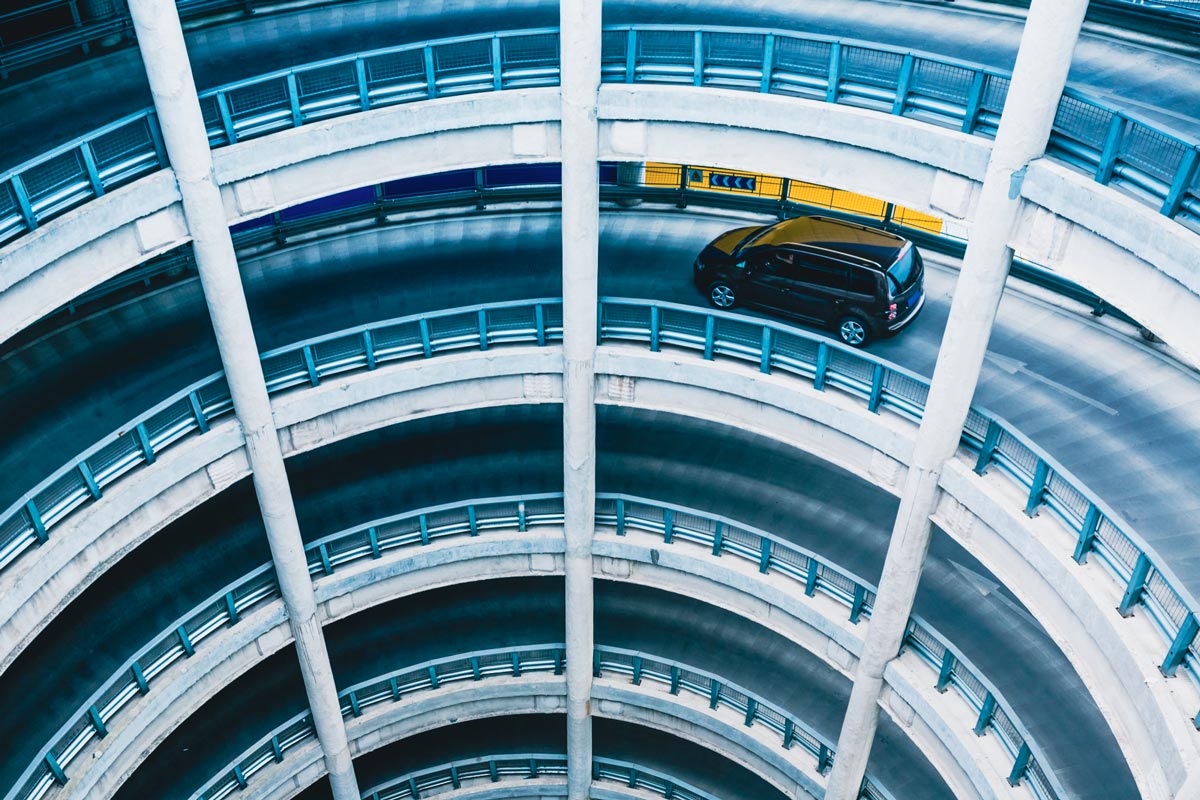 Mehrstöckige runde Parkhausrampe mit einem schwarzen Auto auf der oberen Ebene